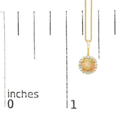 Close-up of a yellow metal necklace shown on a scale, featuring a round multi-color gemstone pendant surrounded by a halo of round white gemstones in shared prong settings, viewed from the front.