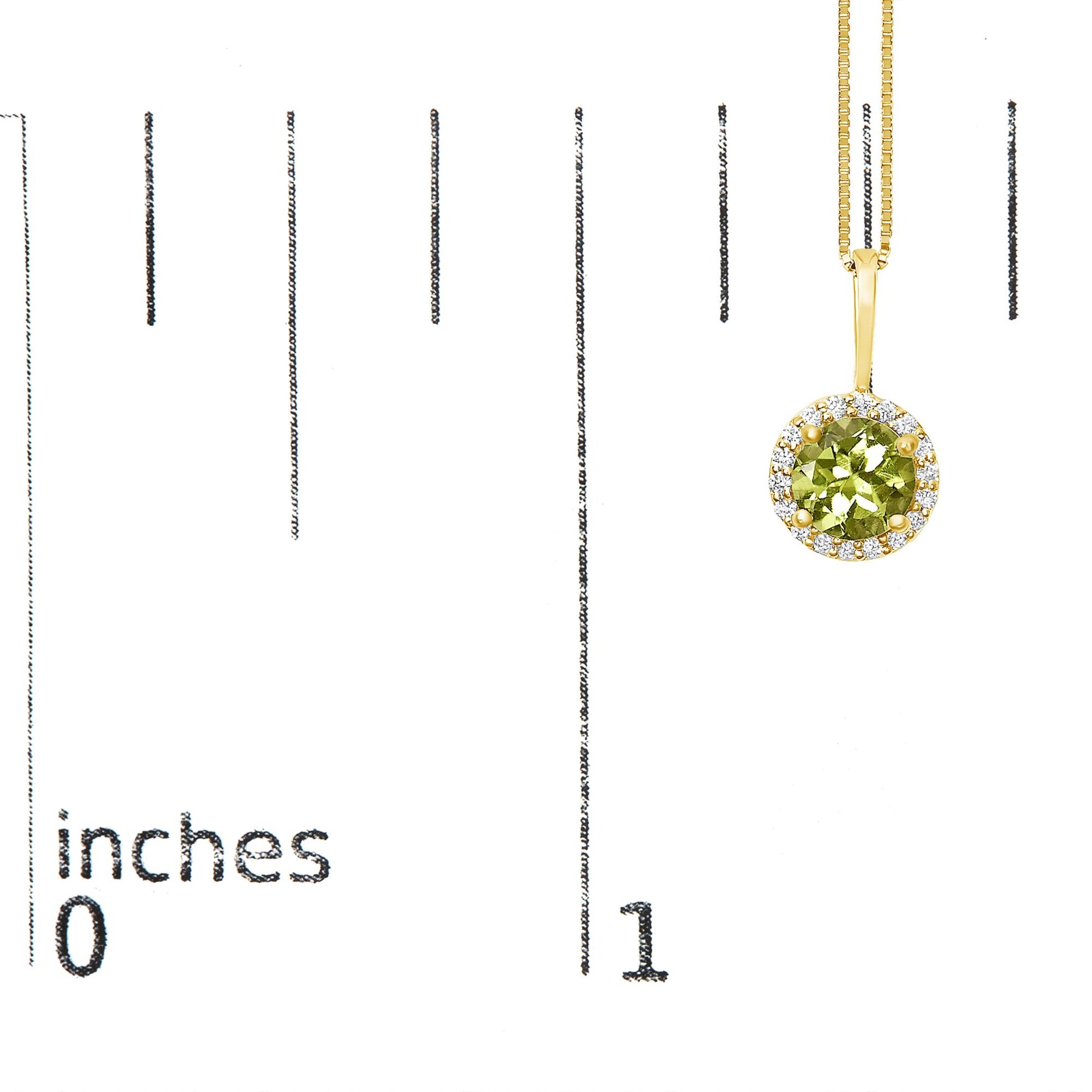Close-up front view of a yellow metal necklace featuring a round green gemstone set in a four-prong setting, surrounded by a halo of small round white gemstones in shared prong settings, shown hanging on a scale with inch markings.