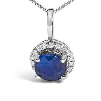 Close-up front view of a white metal necklace pendant with a round blue gemstone in a four-prong setting, surrounded by a curved row of round white gemstones in shared prong settings.