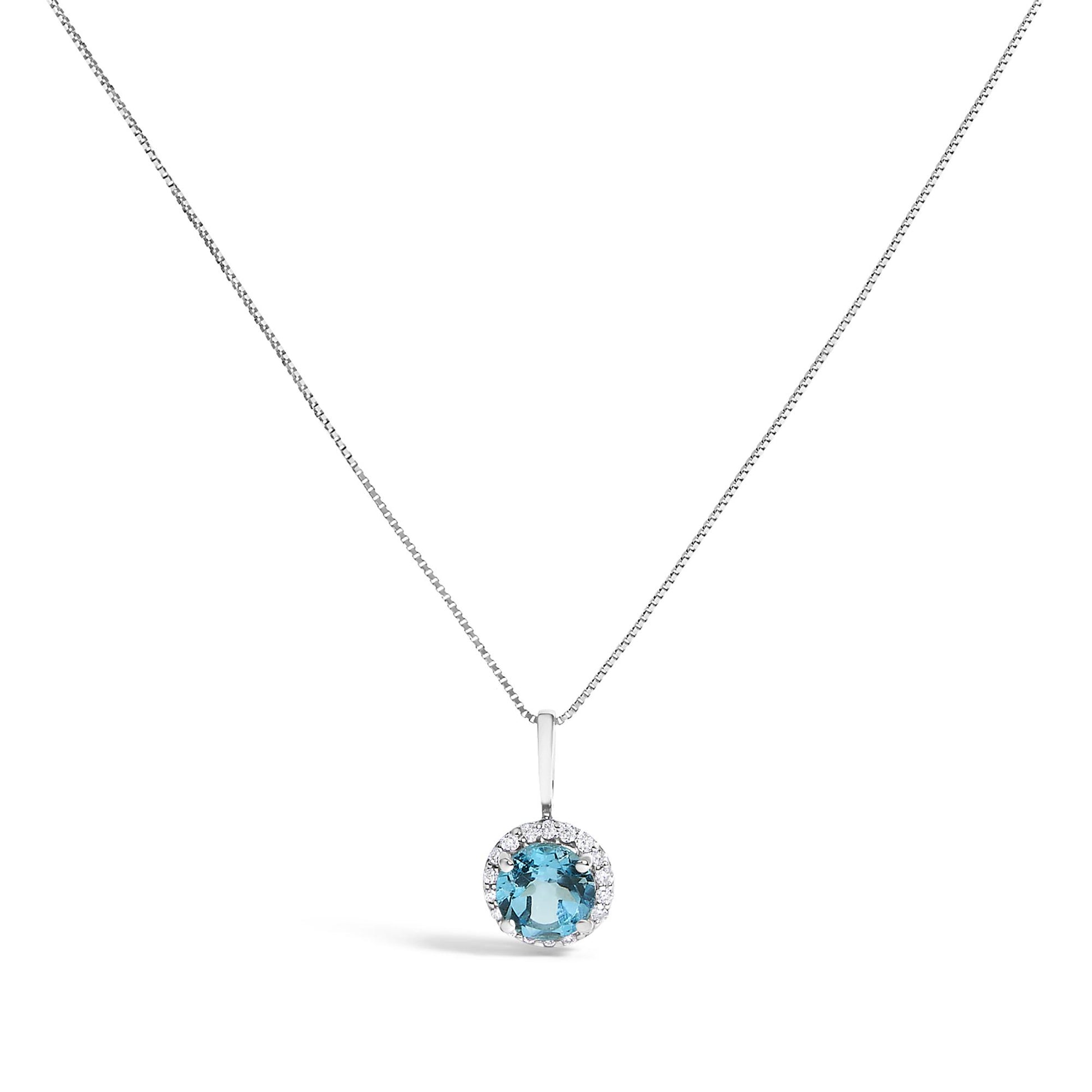 Front view of a white necklace with a round blue gemstone pendant surrounded by small round white gemstones, set on a thin chain, shown against a white background.