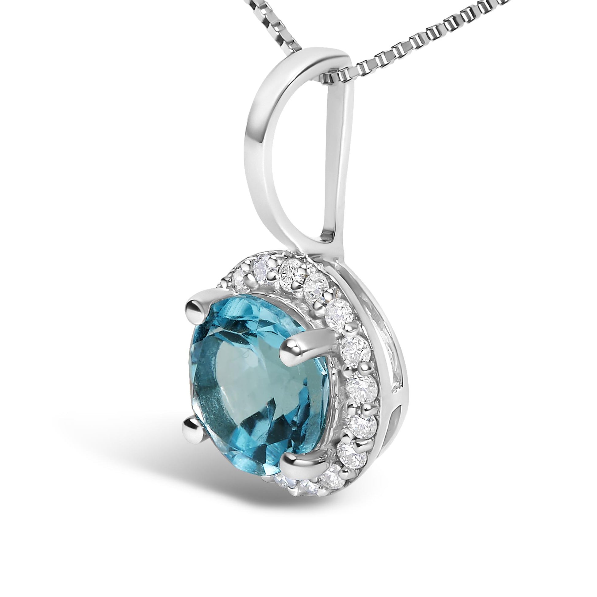 White metal necklace pendant shown in a close-up, angled shot, featuring a round blue gemstone set with four prongs, surrounded by multiple small round white gemstones in shared prong settings.