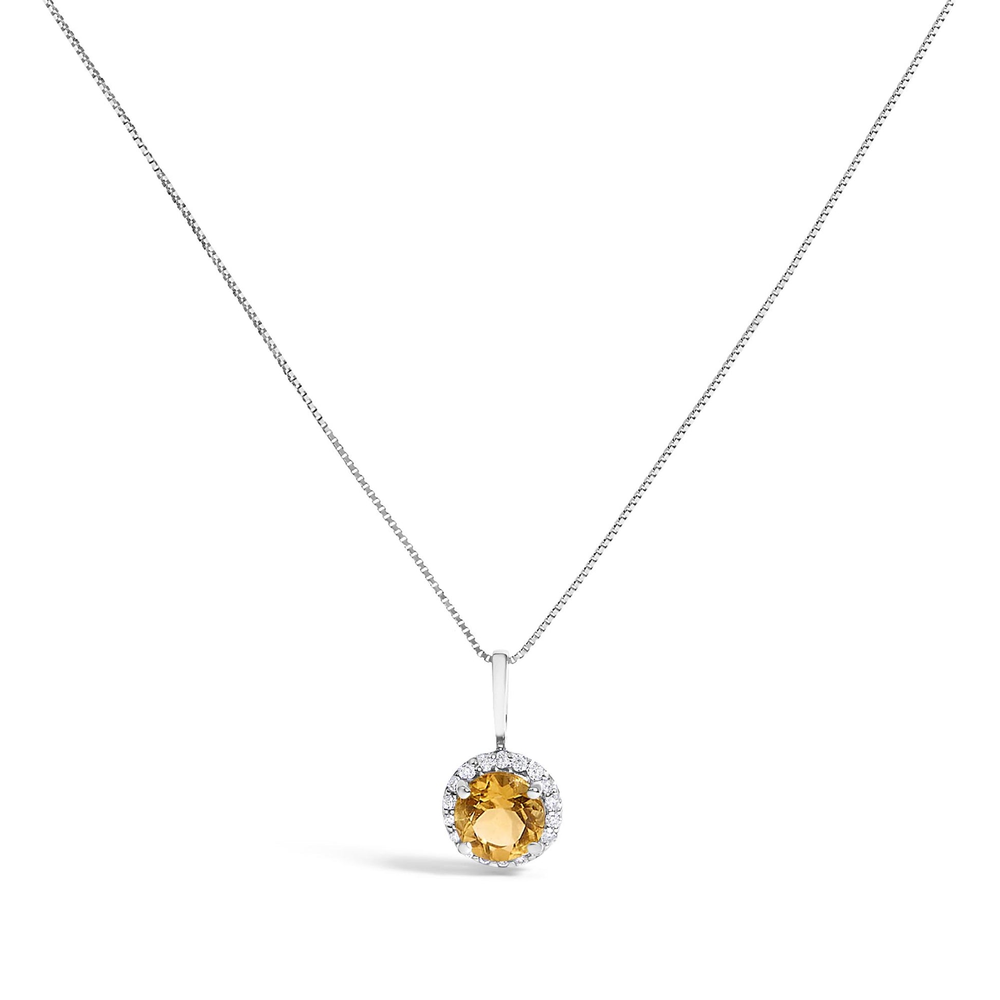 Front-facing shot of a white metal necklace with a round orange gemstone pendant surrounded by small white round gemstones in shared prong settings.