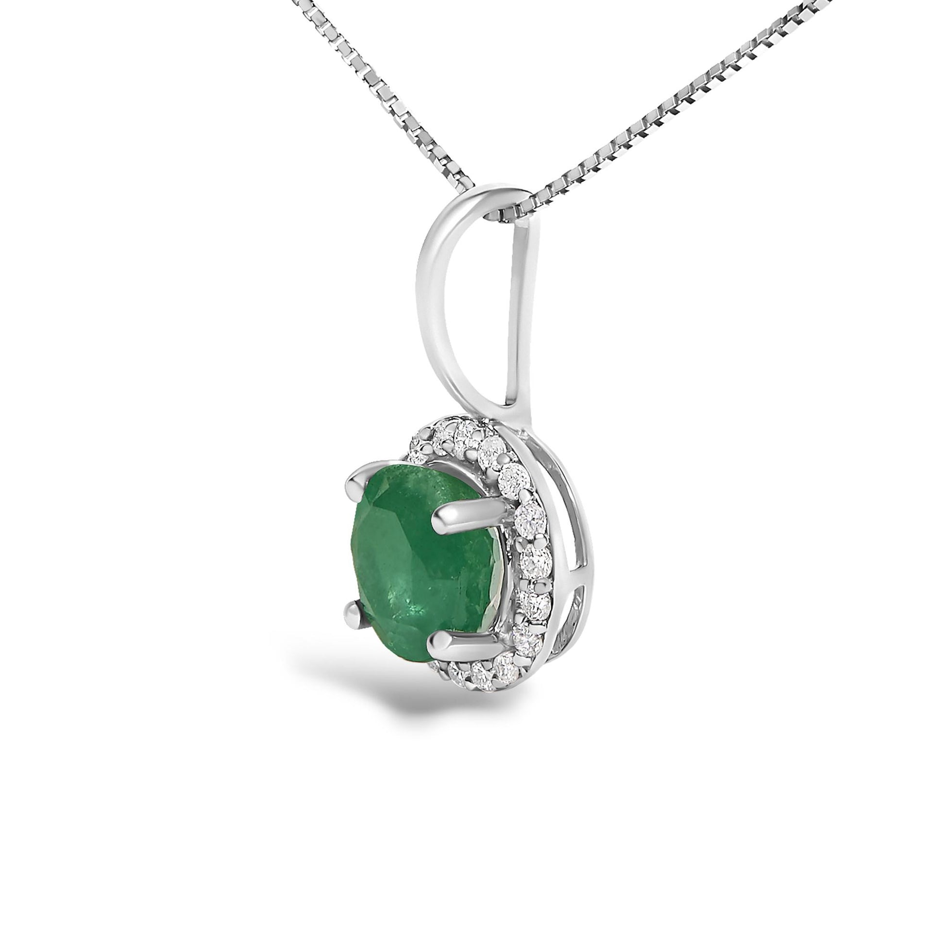 Close-up angled view of a white necklace pendant featuring a round green gemstone held by four prongs, surrounded by a halo of round white gemstones in a shared prong setting, displayed hanging from a white chain.