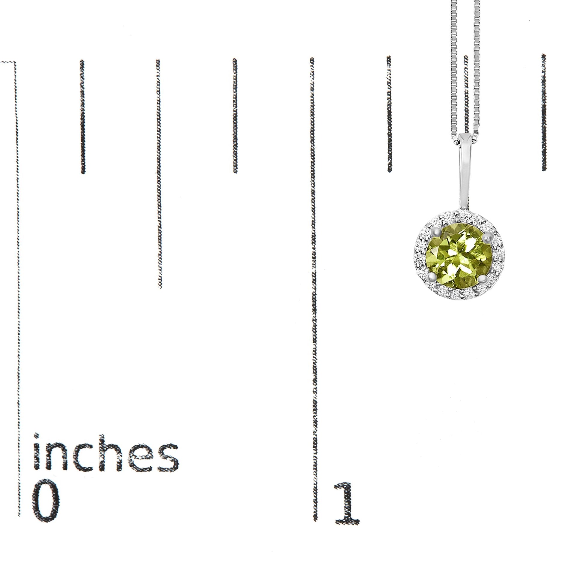 White metal necklace with a round green gemstone pendant surrounded by round white gemstones in a shared prong setting, shown on a scale from a front angle.