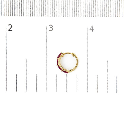 Single yellow metal hoop earring set with red marquise-shaped gemstones along the outer curve, shown flat on a white background with a measurement scale.