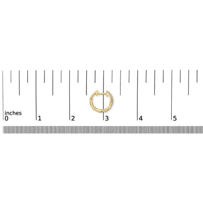 Close-up image of a yellow metal earring with white round pave-set gemstones, shown flat on a ruler for size reference.