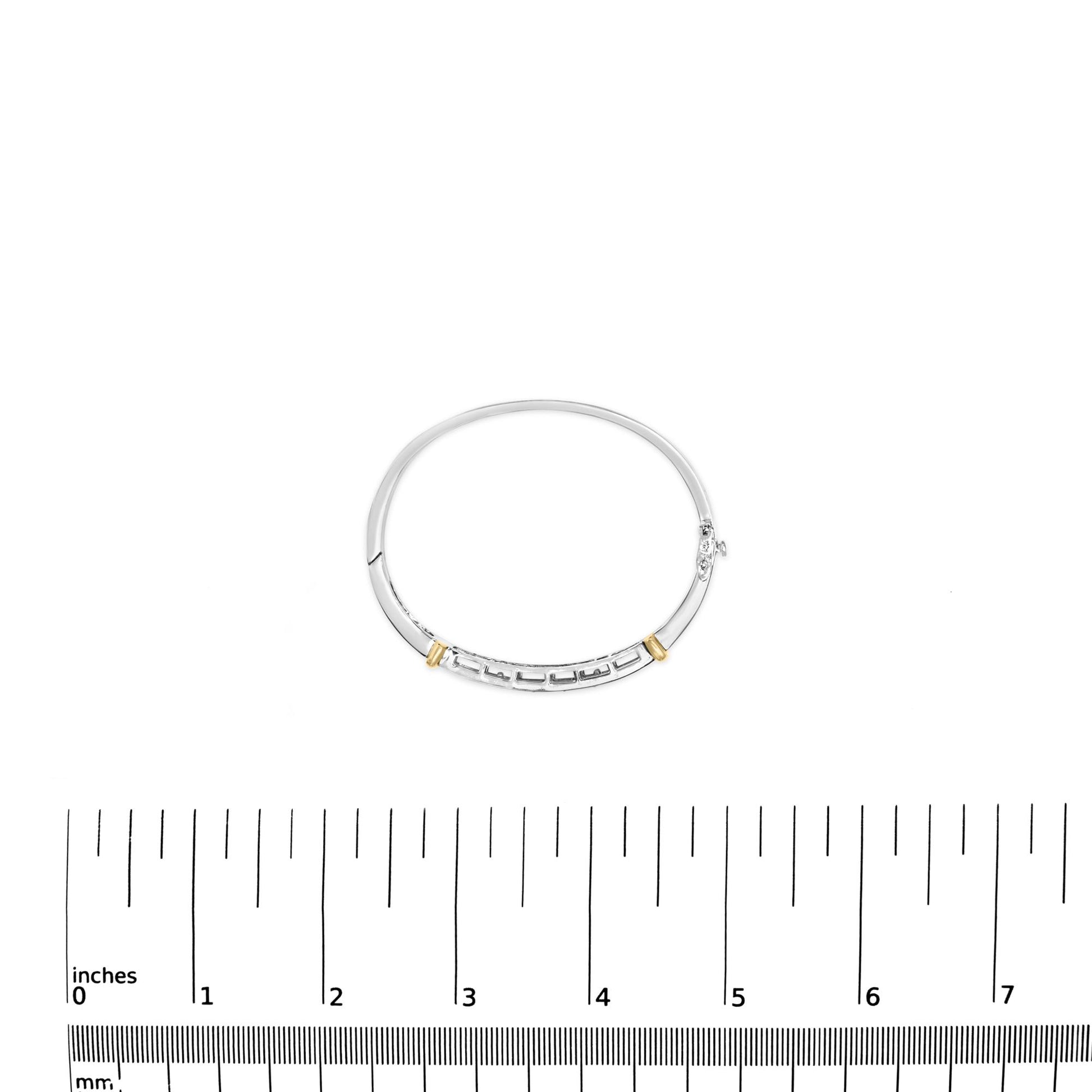 Bracelet in yellow and white metal with white princess shape gemstones in invisible setting, shown from top angle, placed on a ruler for size reference.
