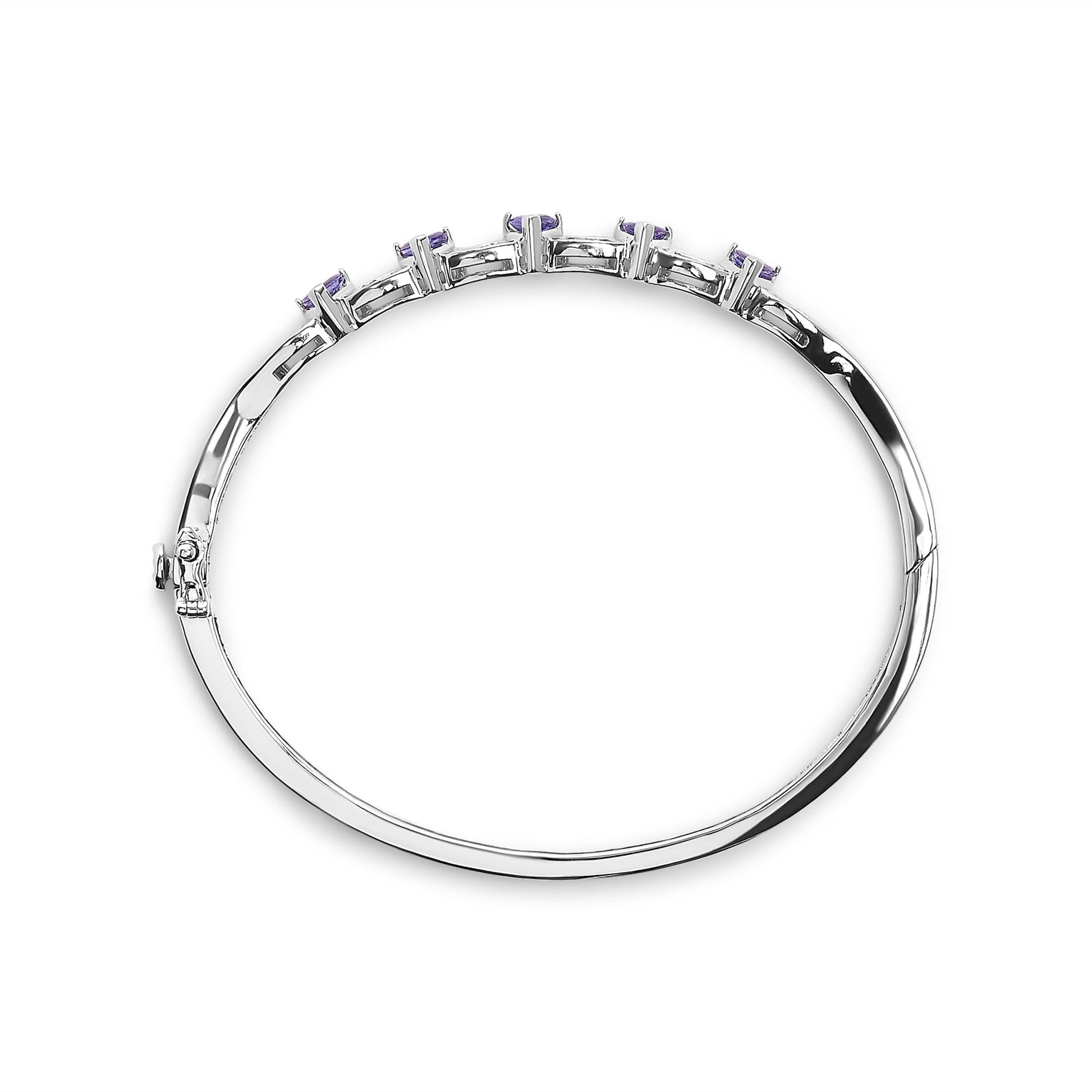Top-down angle of a white metal bracelet with a row of white baguette-shaped gemstones in channel setting and blue trillion-shaped gemstones in three-prong setting.