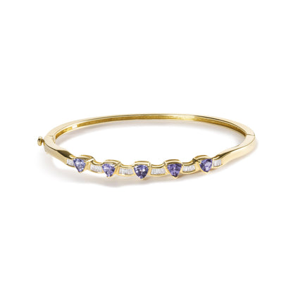 Yellow metal bracelet with alternating blue trillion-shaped gemstones and white baguette-shaped gemstones, shown from a front angle on a white background.