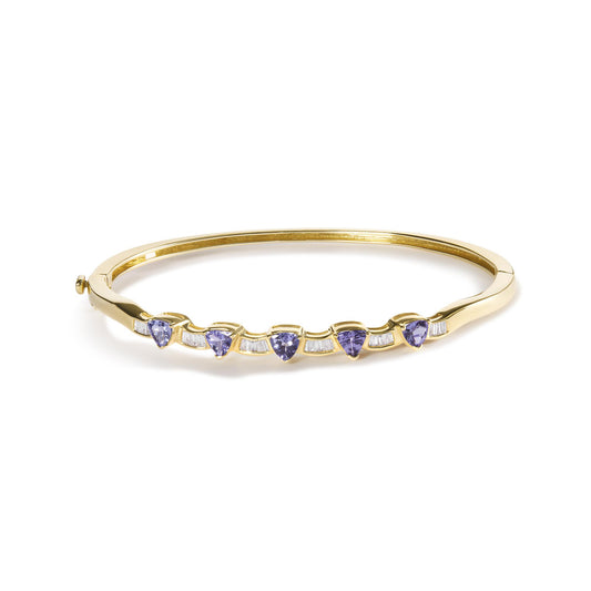Yellow metal bracelet with alternating blue trillion-shaped gemstones and white baguette-shaped gemstones, shown from a front angle on a white background.
