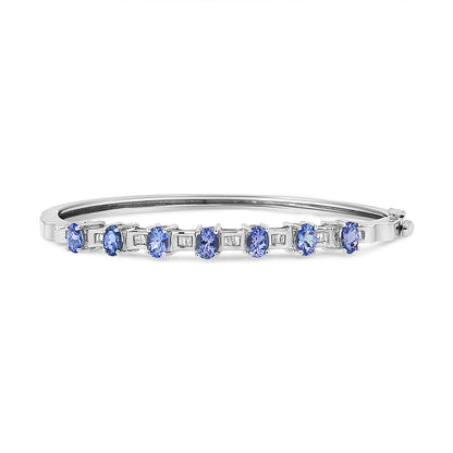 Side view of a white metal bracelet featuring alternating blue oval-shaped gemstones in prong settings and white baguette-shaped gemstones in channel settings.
