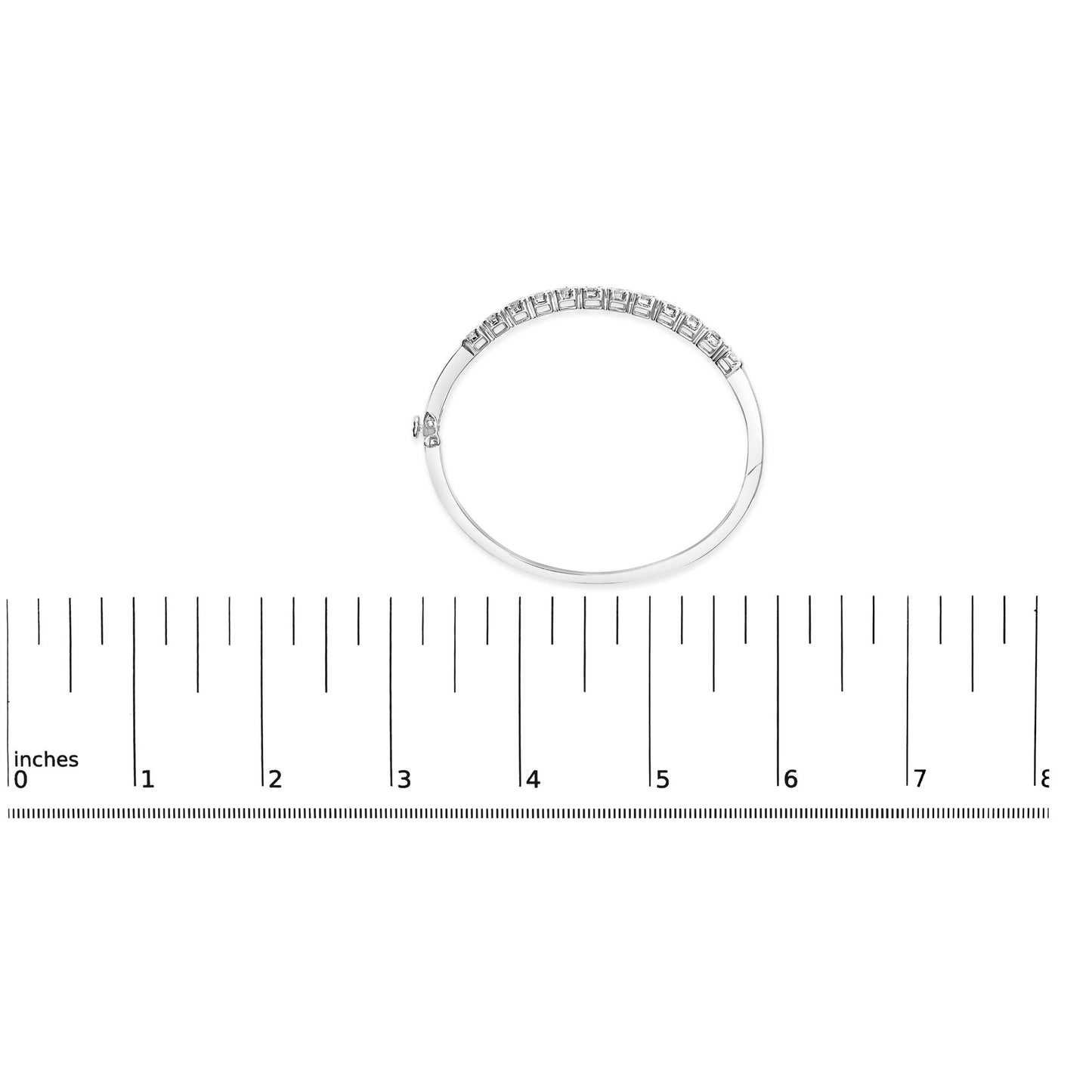 Top view of a white metal bracelet with round white gemstones in pave setting, placed on a ruler for size reference.