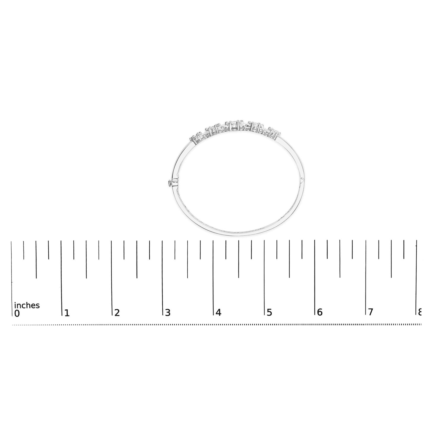 White metal bracelet with round white gemstones in prong settings, shown flat on a ruler for size reference, top-down view.