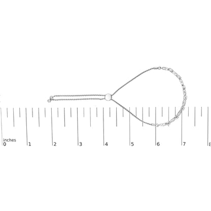 White metal bracelet with round white gemstones in miracle and prong settings, displayed flat on a ruler for size reference, top-down angle.