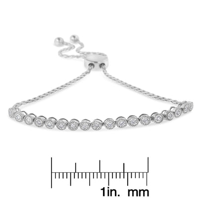 Front-facing close-up of a white metal bracelet with a row of round white gemstones in miracle settings and an adjustable sliding clasp.