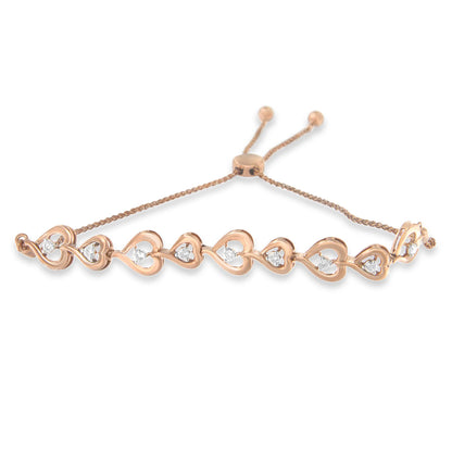 Rose metal bracelet with linked open heart shapes, each set with a round white gemstone, shown from a front angle.