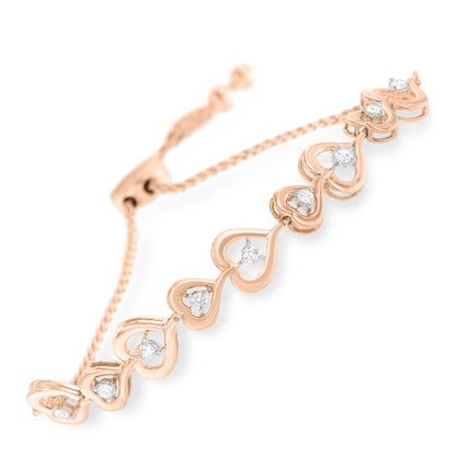 Close-up angled view of a rose-colored bracelet featuring heart-shaped links each set with a white round gemstone in a prong setting.