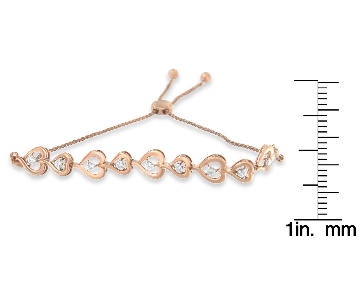 Rose metal bracelet with heart-shaped links, each holding a white round gemstone in prong settings, shown from a top angle and placed next to a ruler for size reference.