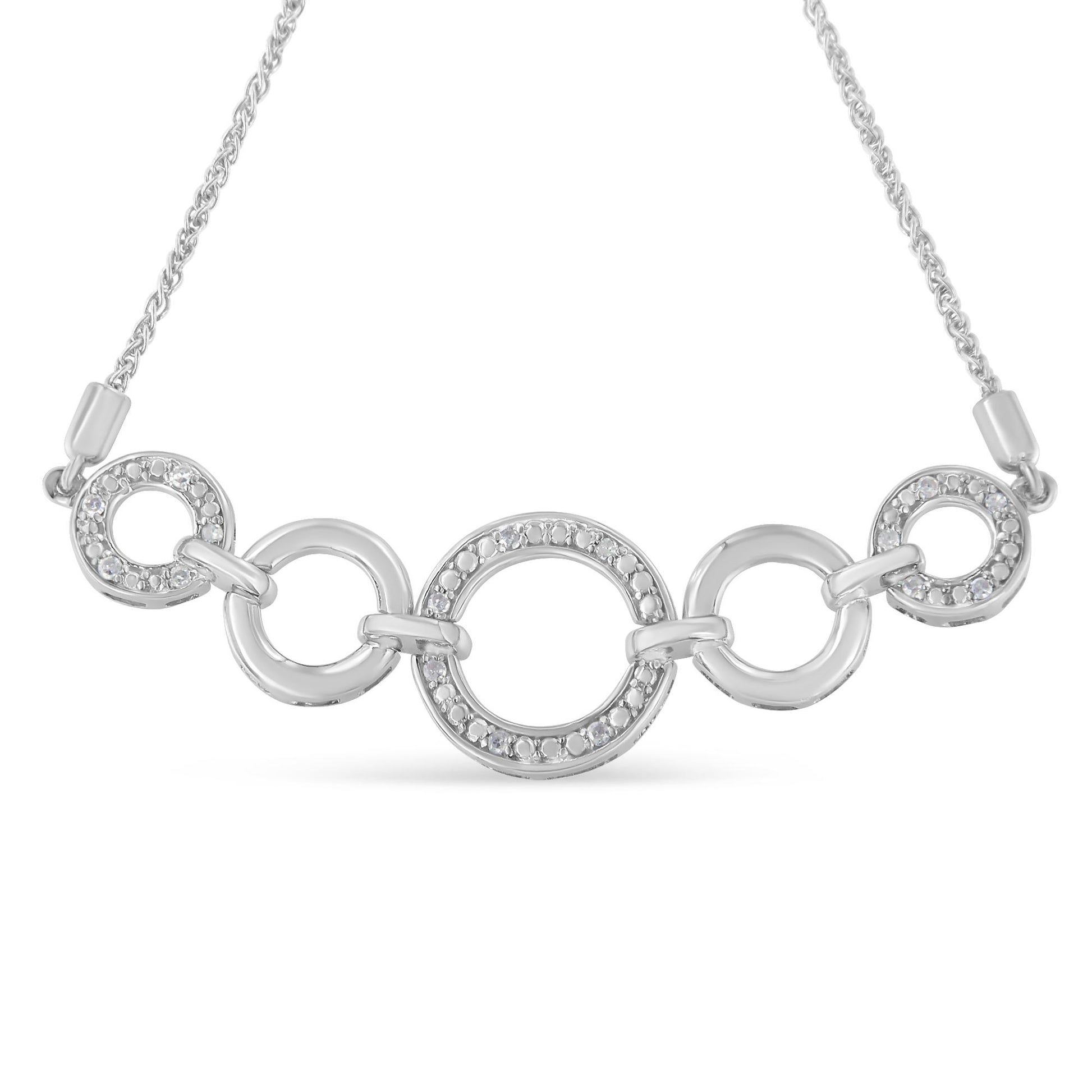 Close-up front view of a white metal bracelet featuring interlinked open circles with some adorned in round white gemstones in pave setting.