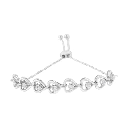 White metal bracelet with linked heart shapes, each set with a round white gemstone, shown from a front angle.