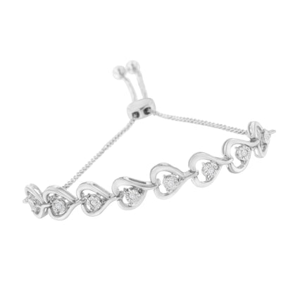 White metal bracelet with wave-shaped links and round white gemstones in miracle setting, shown at an angle.
