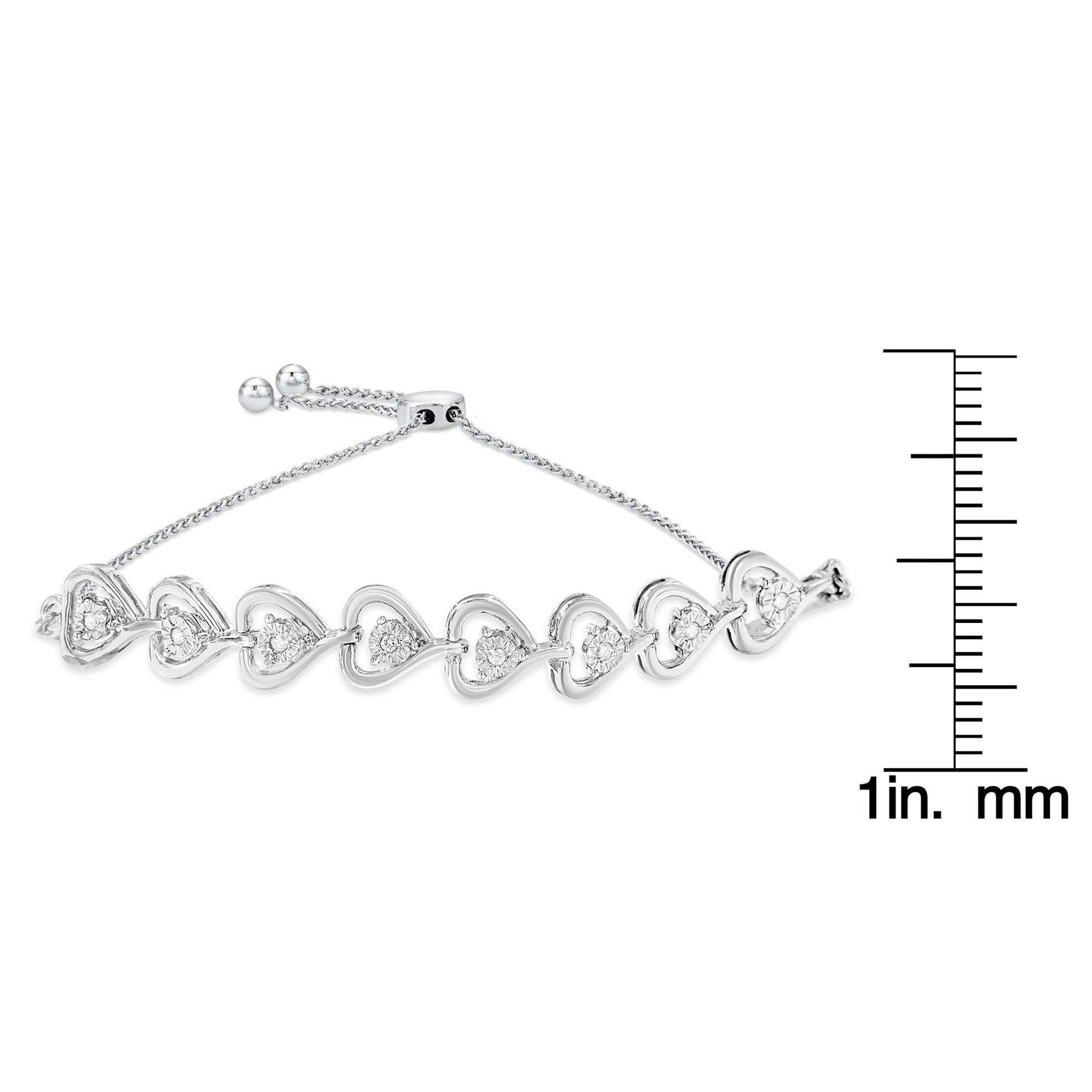 White metal bracelet with heart-shaped links, each set with round white gemstones in a miracle setting, shown from a side angle on a scale for size reference.