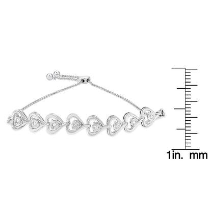 White metal bracelet with heart-shaped links, each set with round white gemstones in a miracle setting, shown from a side angle on a scale for size reference.
