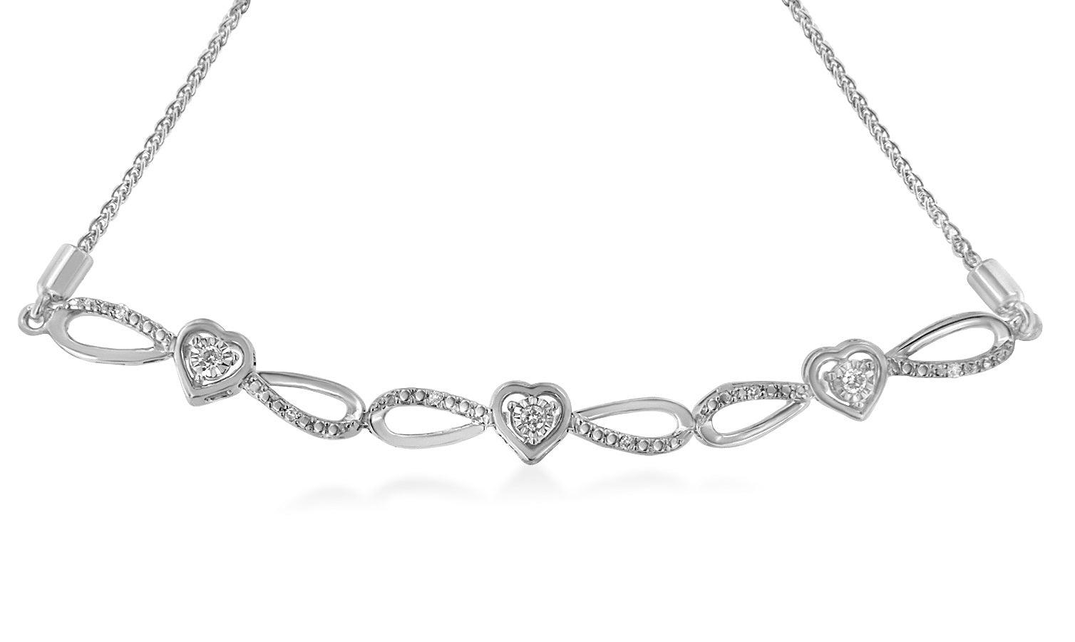 Front-facing shot of a white metal bracelet with alternating heart-shaped settings containing round white gemstones and open loop designs, connected by a fine chain.