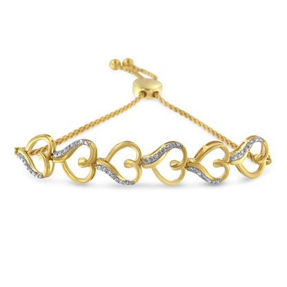 Yellow metal bracelet with alternating heart shapes and curved lines set with small white gemstones, shown from a slightly elevated front angle.