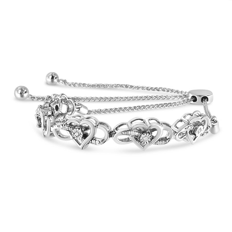 White bracelet photographed from a front angle, featuring interlocking heart shapes each set with white round gemstones, and adjustable chain ends with small round bead details.