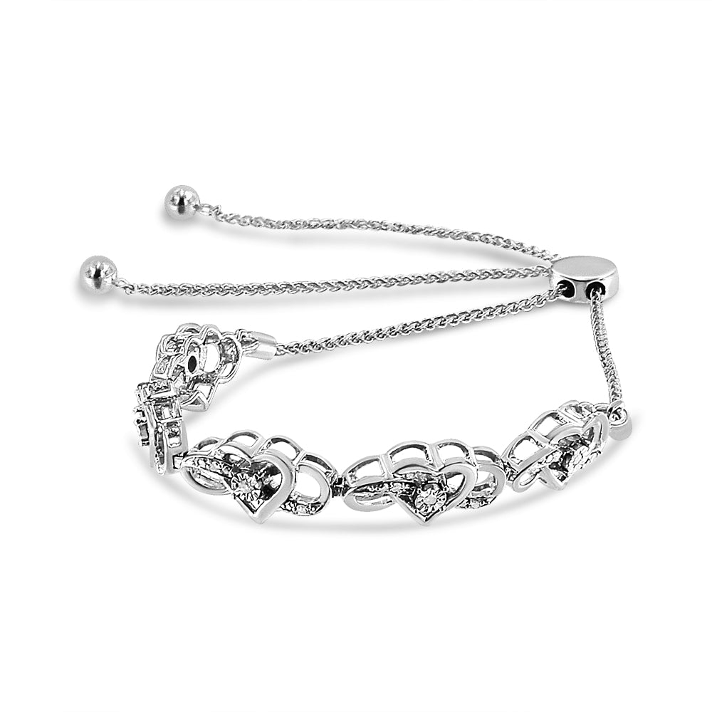 White metal heart-shaped bracelet with round white gemstones in miracle settings, shown from an angled top view.