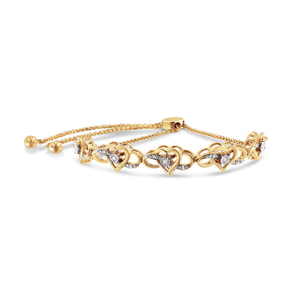 Yellow metal bracelet with heart-shaped links accented with white round gemstones in prong and miracle settings, shown in a front angled view.