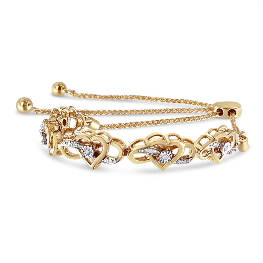 Yellow metal bracelet with heart-shaped links, each featuring round white gemstones in prong and miracle settings, shown at a slight angled top view.