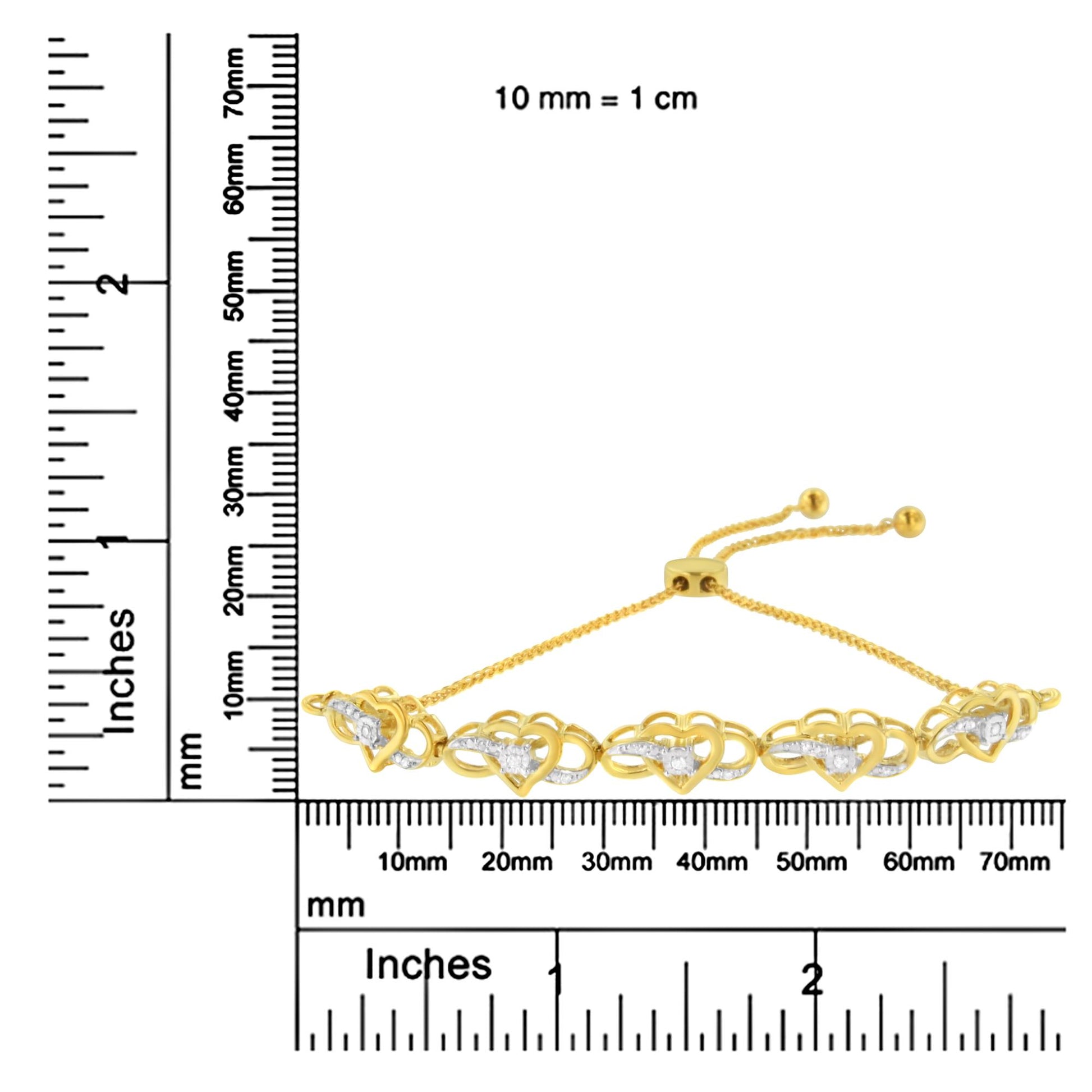Yellow metal bracelet with heart-shaped links featuring white gemstones in miracle and prong settings, shown on a ruler for size reference, front angle.