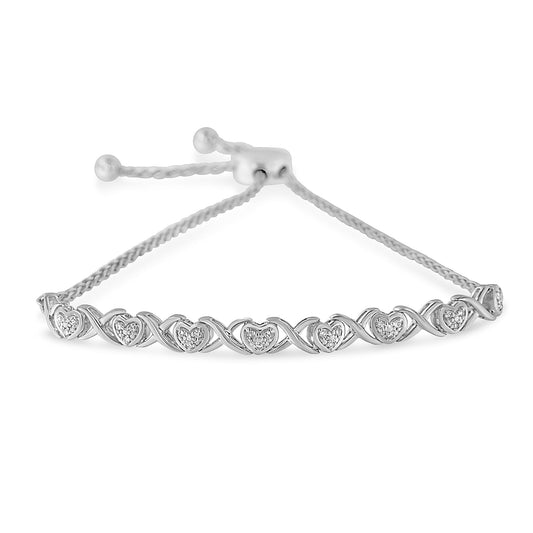 White bracelet with heart shapes featuring round white gemstones in pave setting, shown from a front angle.