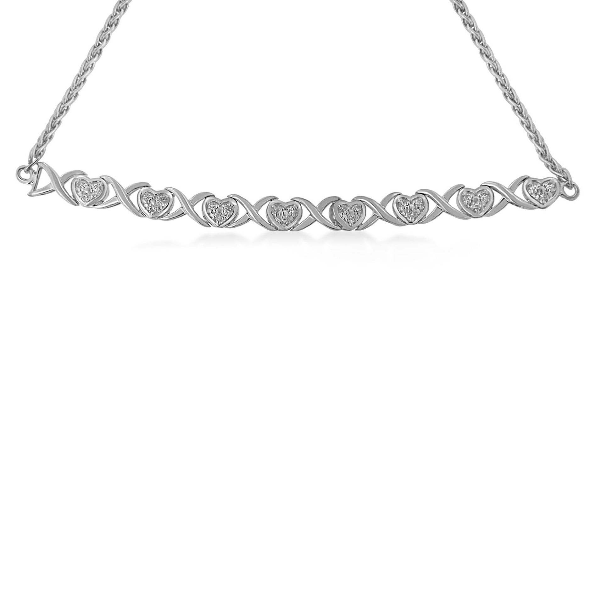 Front-facing shot of a white metal bracelet with heart-shaped links and round white gemstones in pave setting.