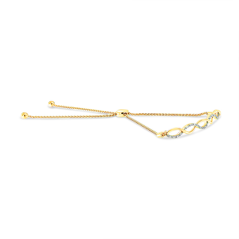 Yellow metal bracelet with a wave design featuring round white gemstones in prong settings, shown in a side angle.