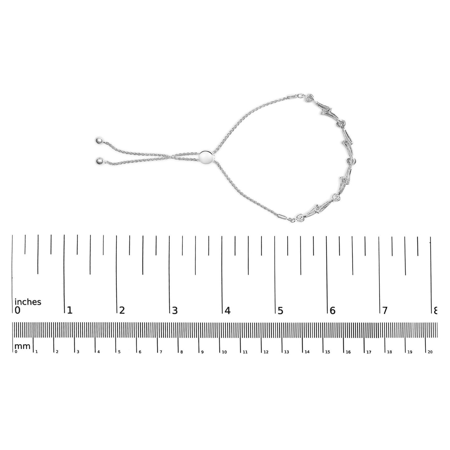 White metal bracelet with round pave-set white gemstones, shown flat on a ruler for size reference, top-down angle.