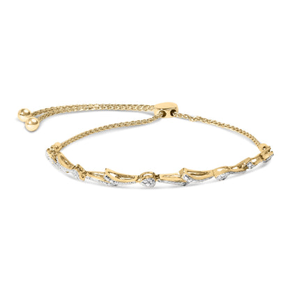 Yellow metal bracelet with heart-shaped and curved segments pavé set with white round gemstones, shown flat from above.