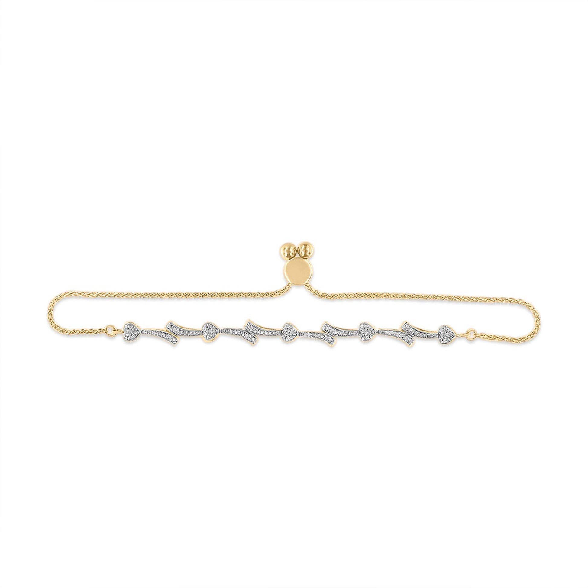 Yellow bracelet with linked heart and arrow shapes set with white gemstones in a pave setting, shown from above on a white background.