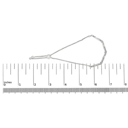 White metal bracelet with linked and chain segments and a sliding bead, featuring round white gemstones in pave setting, displayed flat on a ruler for size reference, top-down angle.