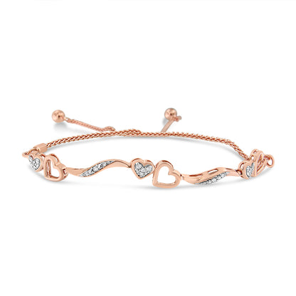 Rose metal bracelet with alternating open heart shapes and wave designs set with white round pave gemstones, shown in a front angled view.