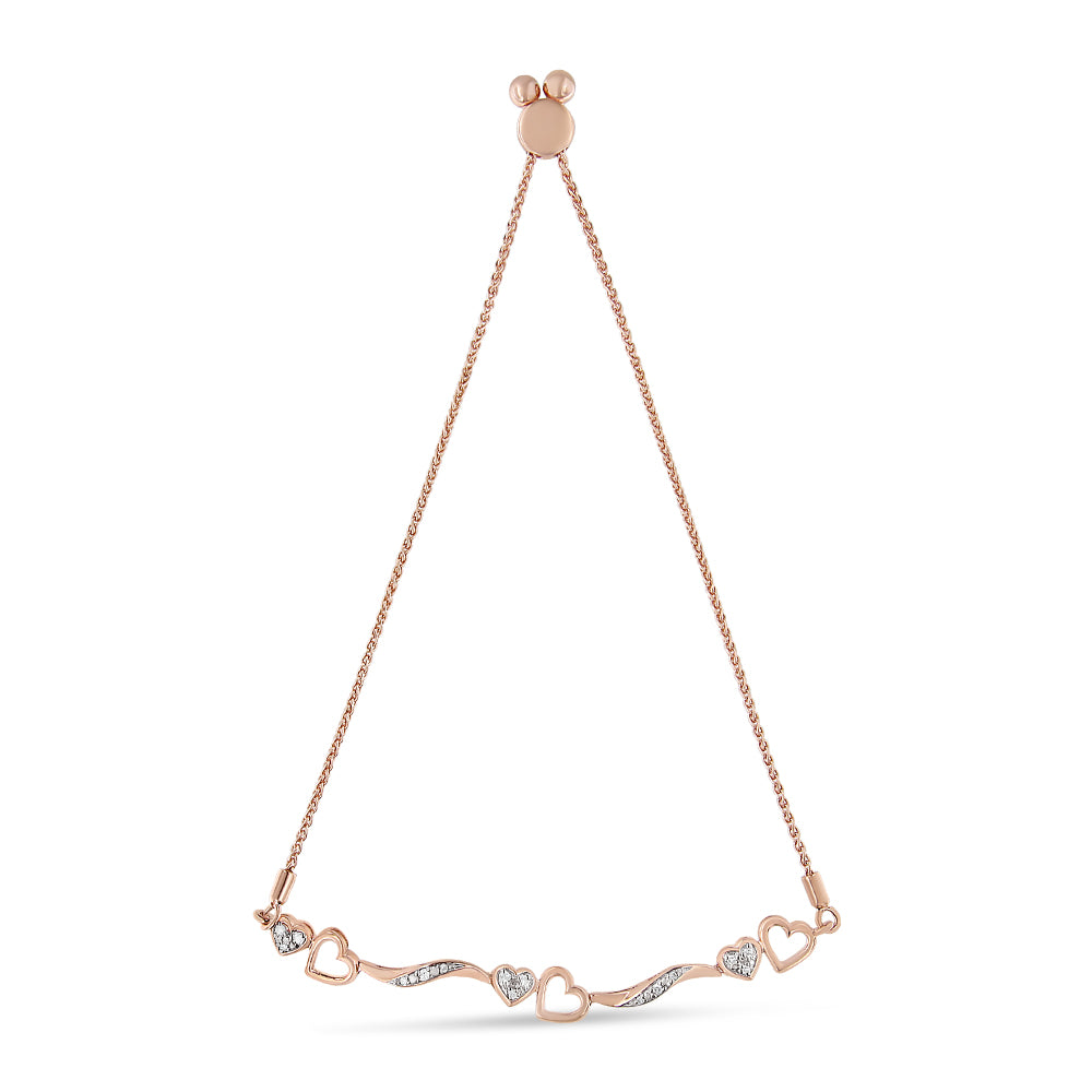 Front-facing shot of a rose-colored bracelet featuring alternating open heart shapes and wavy bars set with small round white gemstones in a pave setting.