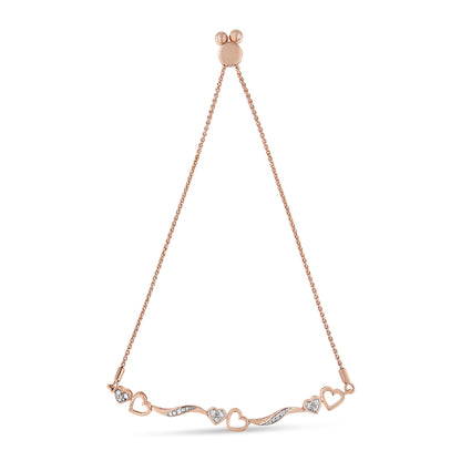 Front-facing shot of a rose-colored bracelet featuring alternating open heart shapes and wavy bars set with small round white gemstones in a pave setting.