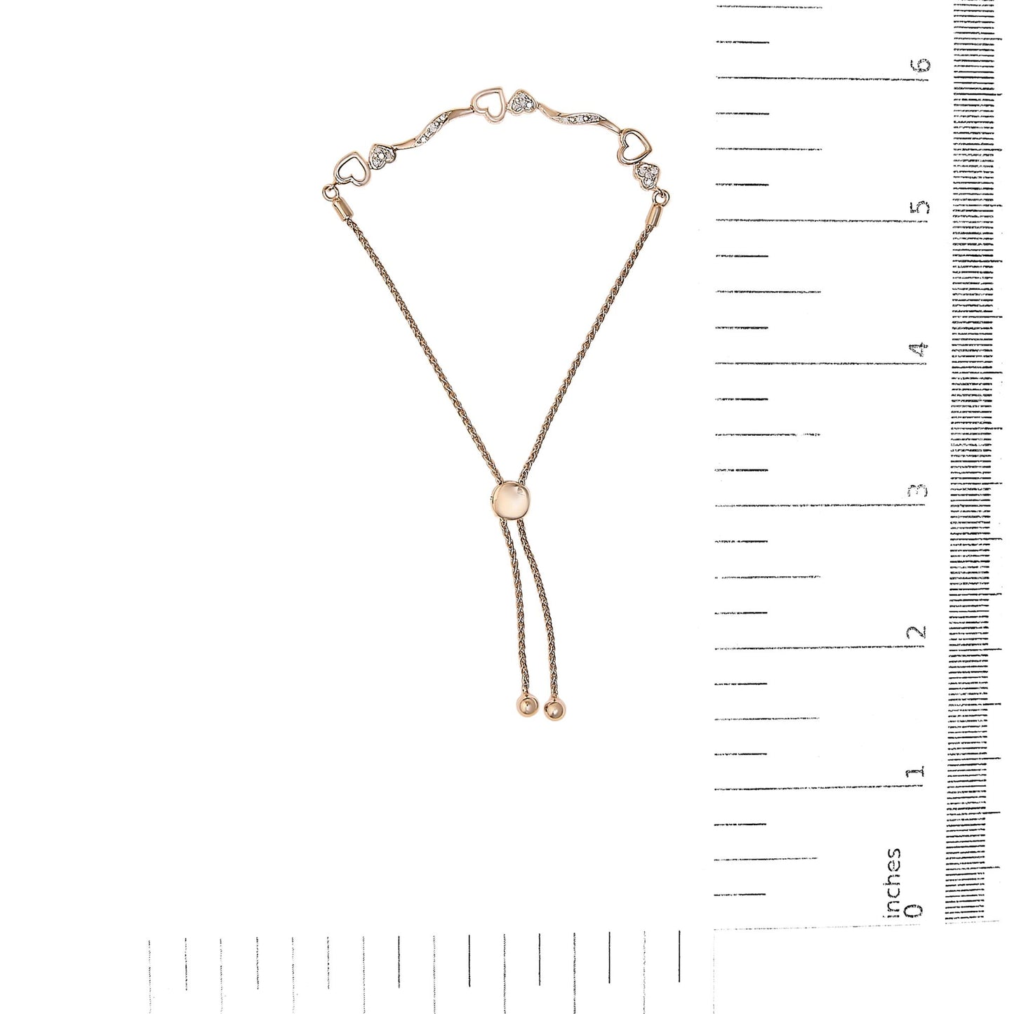 Rose metal bracelet with heart-shaped and curved links featuring white round pave-set gemstones, shown flat on a ruler for size reference, top-down angle.