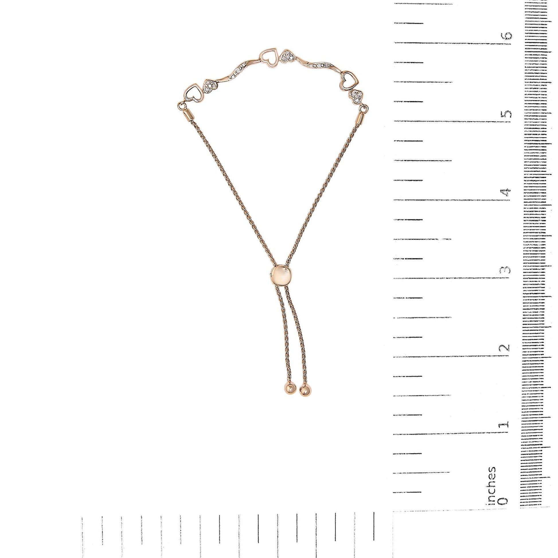 Rose metal bracelet with heart-shaped and curved links featuring white round pave-set gemstones, shown flat on a ruler for size reference, top-down angle.