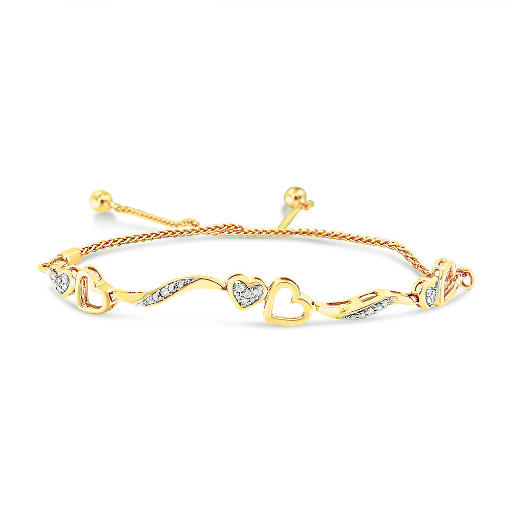 Yellow metal bracelet with alternating open heart shapes and curved links accented with white gemstones, shown in a front angle view.