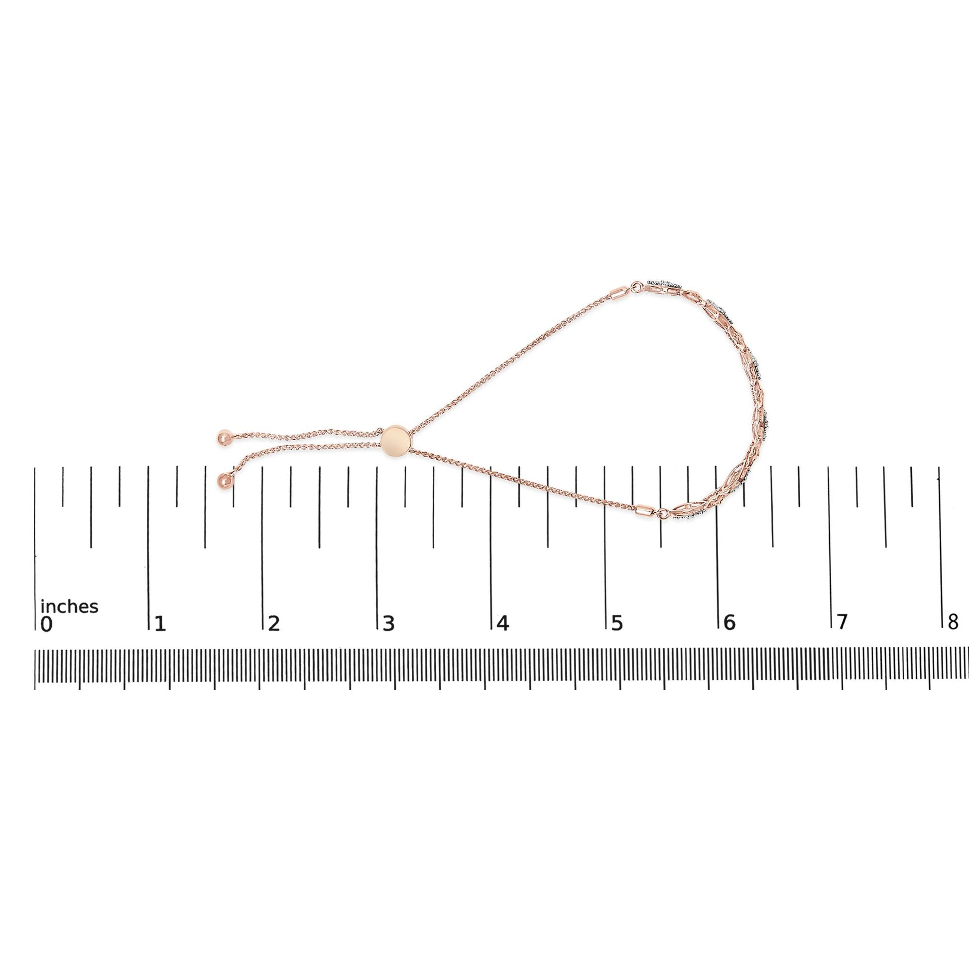 Rose metal bracelet with round white gemstones in pave setting, laid flat on a ruler for size reference, photographed from above.