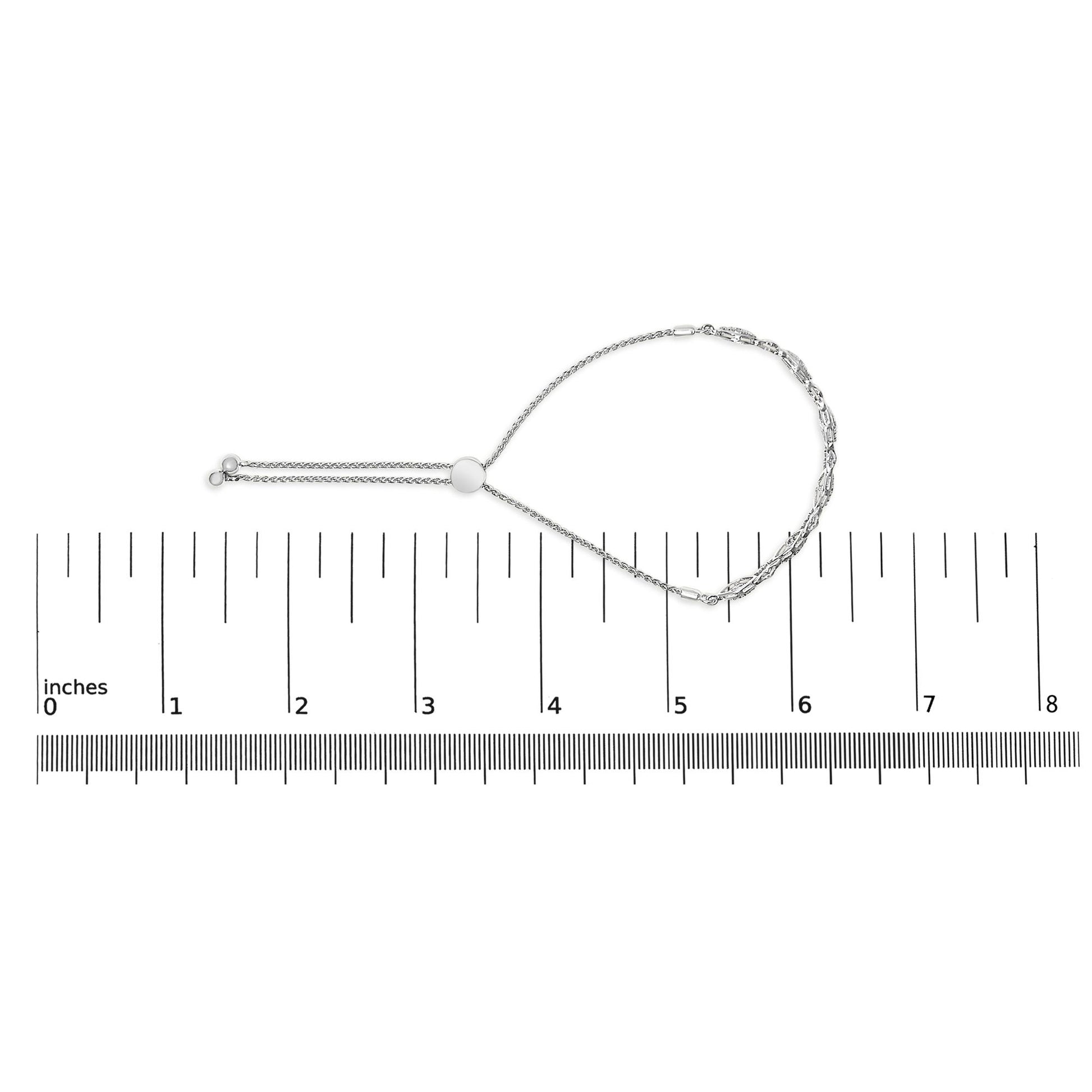 White metal bracelet with round white gemstones in pave setting, shown in a top-down view on a ruler for size reference.