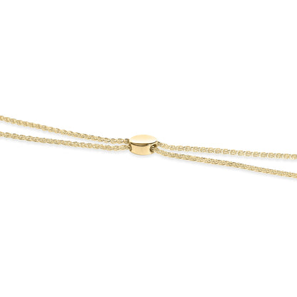 Close-up front angle of a yellow metal bracelet with an oval clasp featuring multiple round white gemstones in a pave setting.